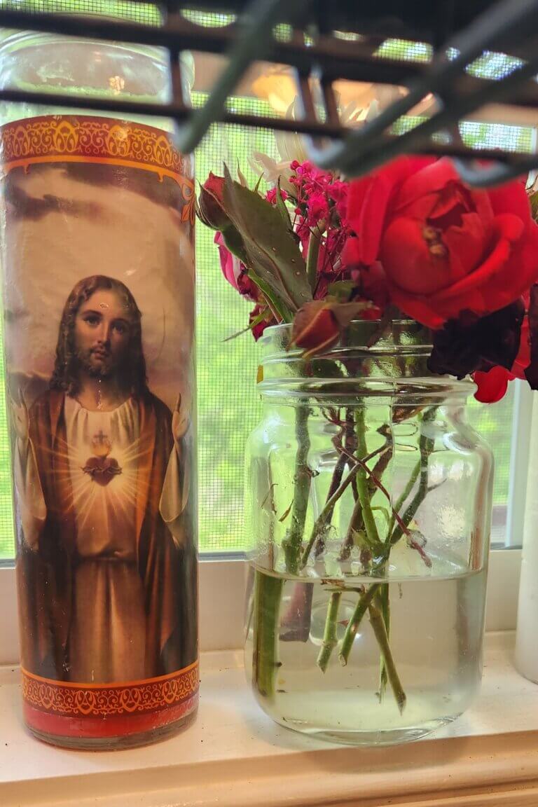 Sacred Heart candle on a kitchen counter as a reminder of Christ’s presence in everyday motherhood.